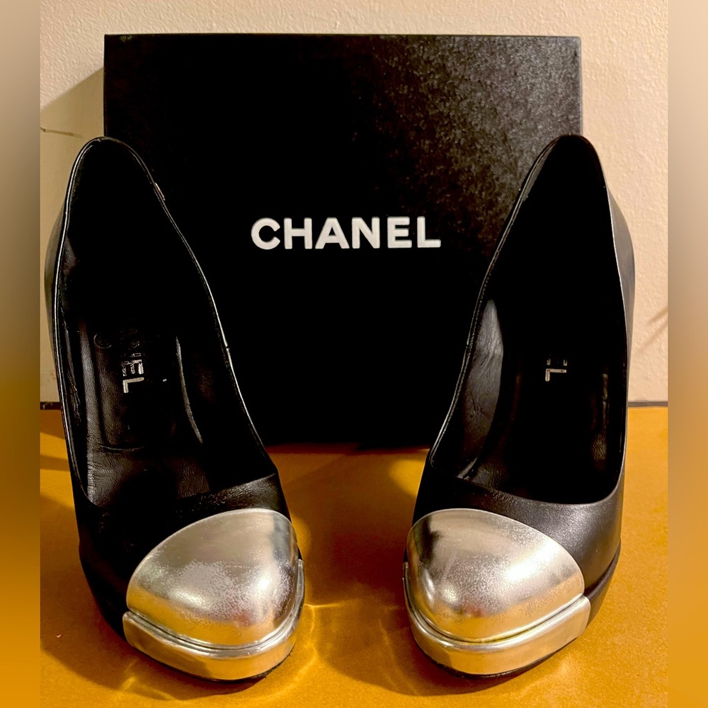 AUTHENTIC Chanel black leather heels with silver cap toe and “CC” logo.